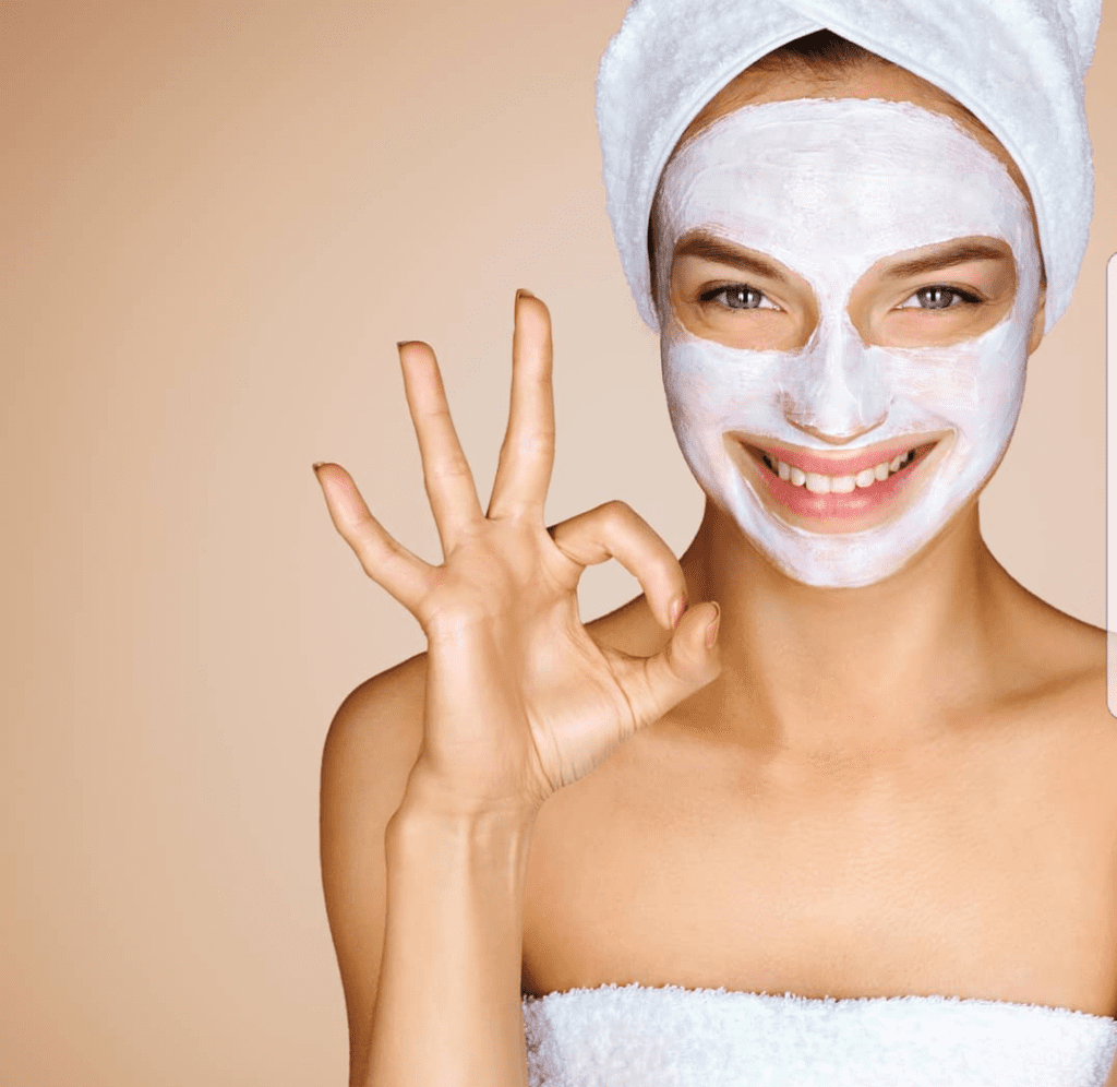 A woman with white face mask and towel on her head.