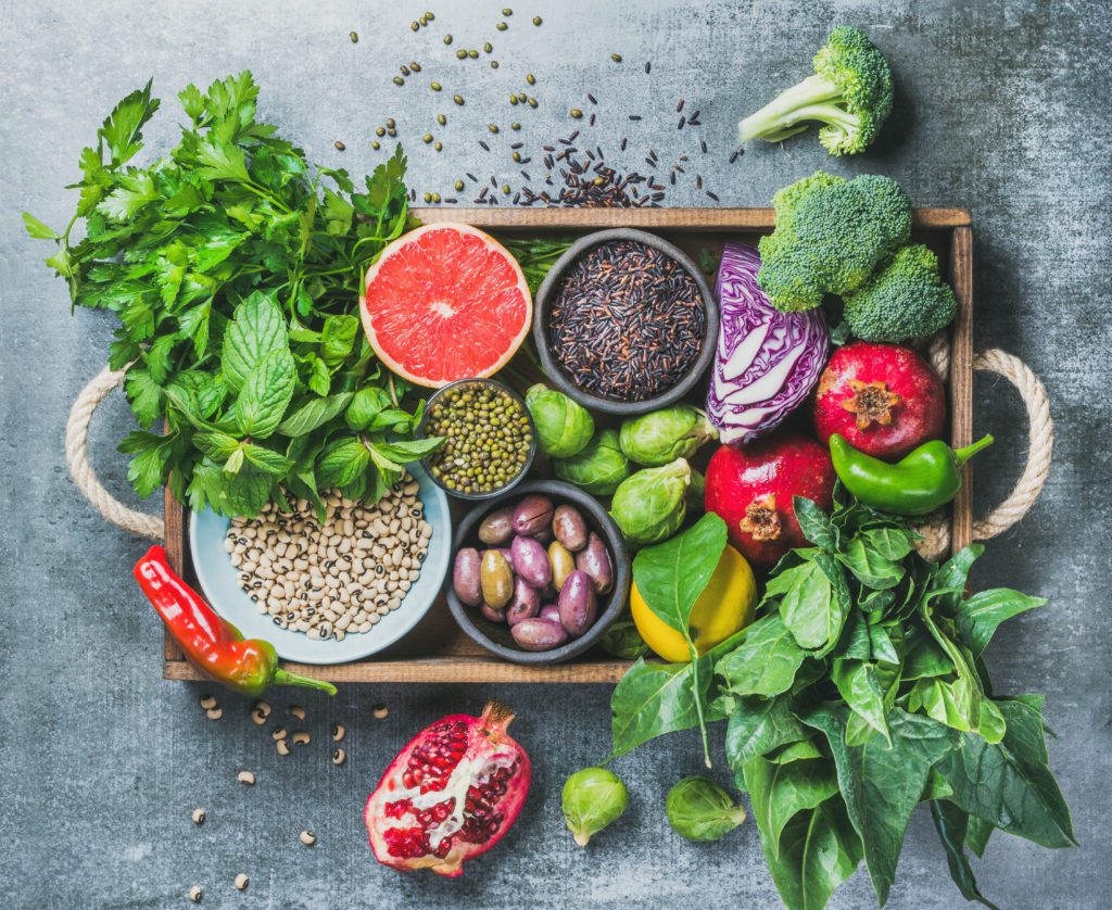 A tray of fresh fruits and vegetables on top of the table.