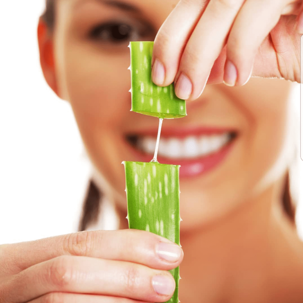 A woman holding up a piece of green food.